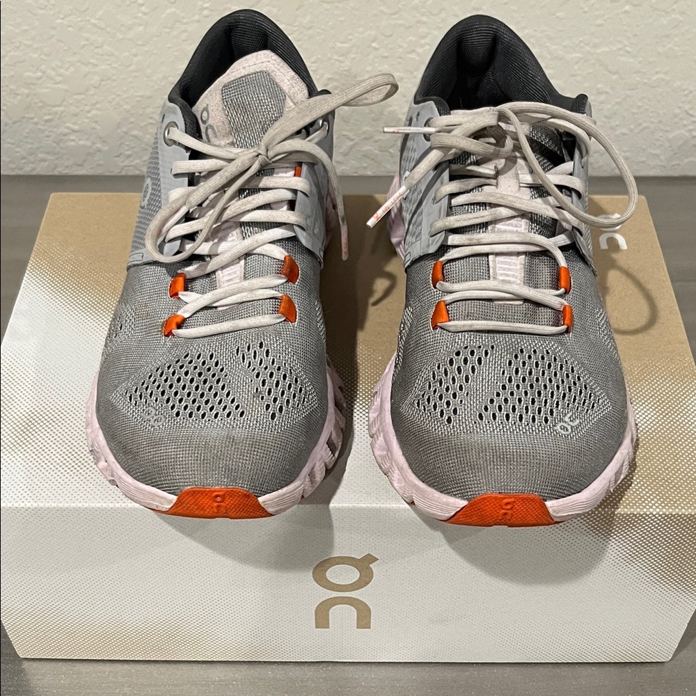On Clouds Women's Athletic Shoes in Gray and Orange.